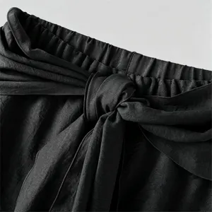 Men's casual pants detail showing elastic waistband with fashionable front tie knot.