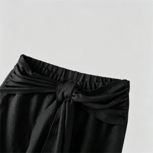 Detailed view of men's black casual pants featuring an elastic waist with a knot strap design.