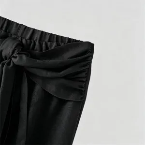 Men's casual pants waist detail close up, featuring elastic waistband, side knot and layered wrap.