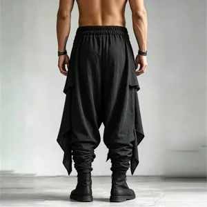 Detailed back view of men's irregular layered harem trousers with drop crotch design.