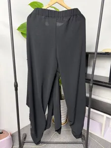 Men's casual black harem trousers featuring a layered wrap design and comfortable cuffed ankles.