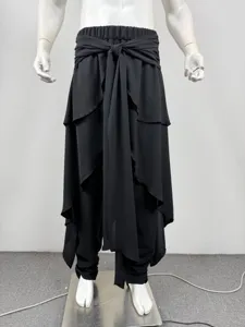 Men's black layered harem pants with tie waist and asymmetric drape design detail view.