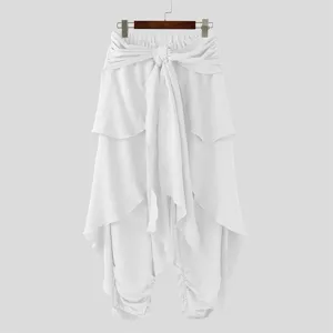Detail shot of men's casual white harem pants featuring layered wrap design and waist tie.