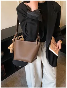 Vue détaillée du sac seau en cuir marron élégant, mettant en valeur sa texture unique.
