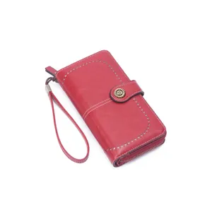 Red leather long wallet for women, vintage clutch purse with wrist strap and zipper closure.