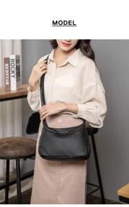 Detailed shot of a black litchi pattern leather shoulder bag worn by model in an indoor scene.