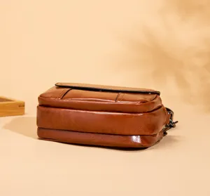 Detailed view of the brown leather multi-layer cross-body shoulder bag texture and finish.