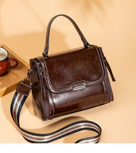 Close-up detail of retro brown women handbag with stylish web stripe strap and premium leather.