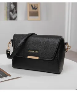 Vue détaillée du sac à bandoulière en cuir texturé noir avec quincaillerie dorée.