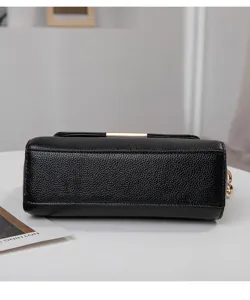 Vue détaillée du sac à bandoulière en cuir noir, montrant texture fine et quincaillerie.