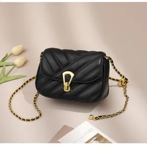 Close-up detail of the black quilted shoulder bag featuring gold chain strap and metal lock.