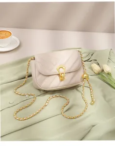 Close-up detail of beige quilted shoulder bag with chic gold chain and refined lock.