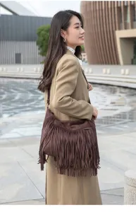 Vue détaillée d'un sac à bandoulière rétro à franges porté par un mannequin, design.