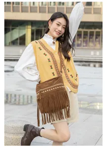 Detail shot of retro brown suede fringe crossbody bag with chic metal studs, outdoor lifestyle view.
