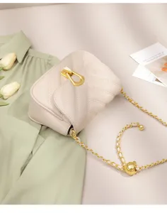 Detailed view of elegant quilted crossbody shoulder bag with chic golden chain and lock.