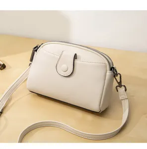 White minimalist double layer crossbody shoulder bag detail view with zipper and magnetic closure.