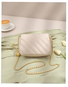 Beige quilted shoulder bag detail, elegant chevron pattern with luxury gold chain strap.