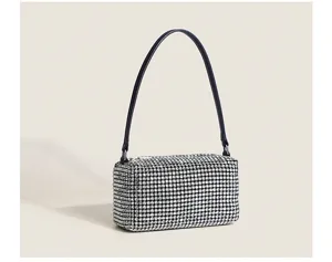 Vue détaillée d'un sac à bandoulière en strass étincelant avec une fine lanière noire.