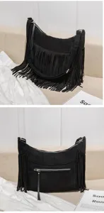 Détail du sac porté épaule en suédine noire à franges montrant la fermeture à glissière.