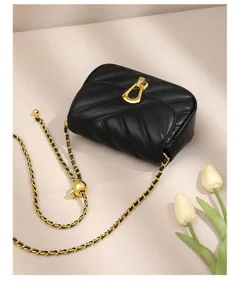 Black quilted leather shoulder bag with gold chain strap detail, elegant minimalist design.