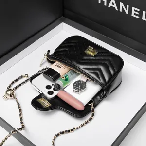 Black quilted crossbody bag with chain strap, chevron pattern and metallic turn-lock closure.