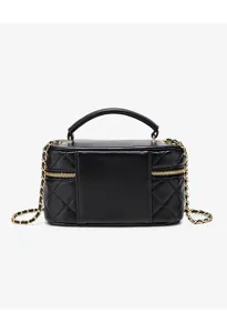 Black quilted vanity bag detail shot, featuring gold chain strap and metal zippers.