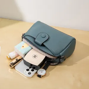 Minimalist solid color leather crossbody bag, blue-green dual-compartment shoulder handbag.