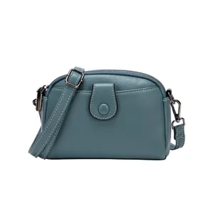 Minimalist teal leather cross-body shoulder bag for women, front pocket main view.