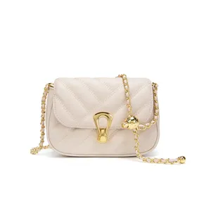 Elegant beige quilted crossbody bag with gold chain strap and stylish metal clasp.