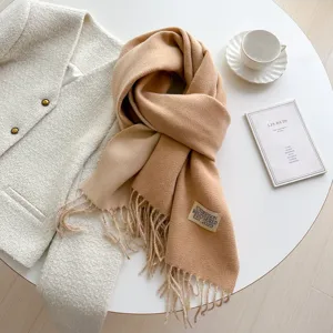 Classic camel cashmere-feel winter scarf featuring elegant fringe and neat branded label detail.