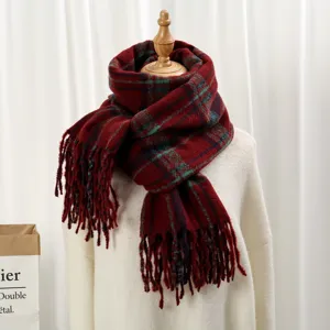 Vue détaillée de l'écharpe d'hiver rouge à carreaux doux, avec de jolies franges et texture.