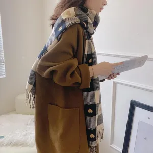 Detail view of winter plaid heart pattern cashmere feel long fringe scarf, cozy warm accessory.