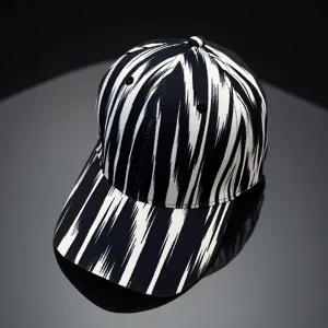 Close-up of black and white ikat patterned baseball cap, showing textured brushstroke details.