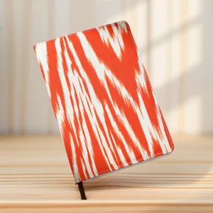 Cuaderno cultural creativo con cubierta de patrón ikat naranja, vista detallada del diario étnico.