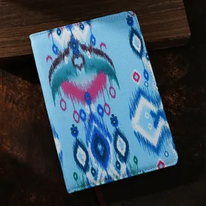 Detalle de cuaderno de tela estilo étnico con cubierta de patrón azul y costuras finas.