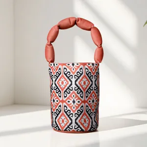 Traditional ethnic style bucket bag with unique padded handle and vibrant pattern design.