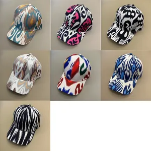 Detail view of Xinjiang ethnic style printed baseball caps, featuring various patterns.