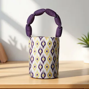 Detailed view of ethnic style bucket handbag featuring vibrant Atlas pattern and purple handle.