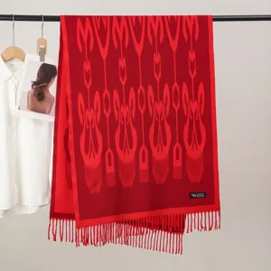 Detailed view of a vibrant red ethnic style woven scarf with fringe trim and warm winter design.