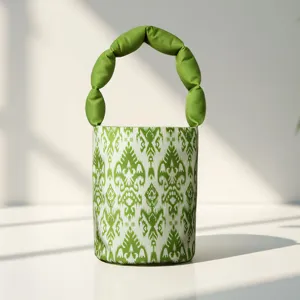 Detailed view of green ethnic ikat pattern cylindrical bucket handbag with unique bubble handle.