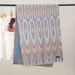Dettaglio della sciarpa in stile etnico con stampa geometrica e finiture a frange.