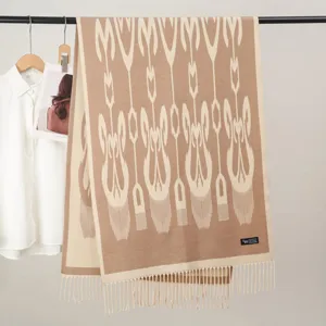 Detailed view of brown ethnic pattern woven winter scarf with fringe design and soft fabric texture.