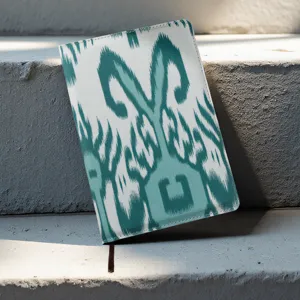Cuaderno tradicional con patrón Ikat y cubierta turquesa con cinta marcapáginas de recuerdo.