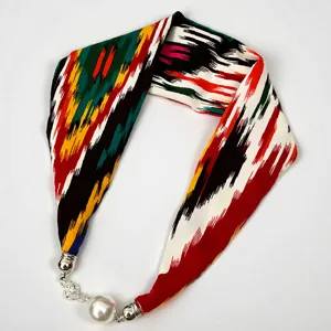 Detail shot of Xinjiang Ikat silk scarf with magnetic pearl necklace buckle accessory.