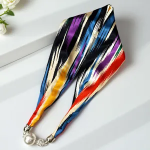 Elegant silk ribbon scarf with magnetic pearl necklace clasp, colorful striped design detail.