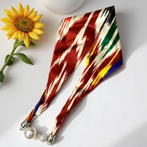 Detailed view of traditional ethnic style silk scarf featuring magnetic pearl necklace clasp.