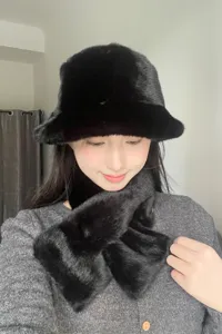 Detailed close-up of a cozy black plush fisherman hat and matching warm winter scarf set.
