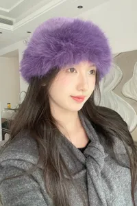 Detail shot of a stylish purple fluffy bucket hat worn by a model, perfect for autumn and winter fashion.