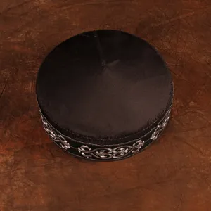 Detailed view of traditional Kazakh style embroidered black men ethnic hat with silver pattern design.