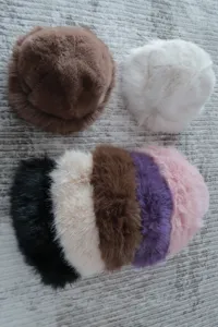 Detail view showing various colors of fluffy plush bucket hats, soft texture for autumn and winter.